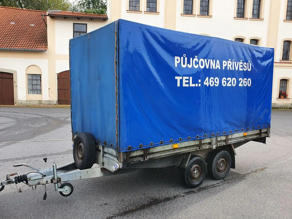 Přívěs č. 1 s modrou plachtou a dvěma nápravami
